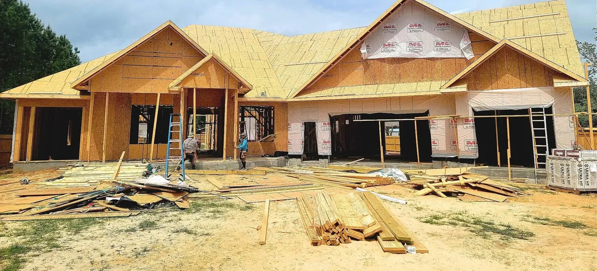 JEH crew framing a large single-story custom home with a multi-gable roof in Beulah