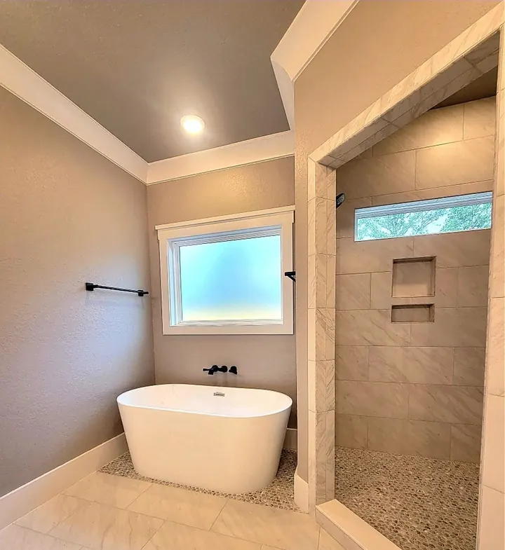 Bathroom with a freestanding soaking tub, black fixtures and a tiled walk-in shower
